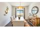The dining room features a rustic wood table, stylish seating, and modern light fixture at 14393 W Wethersfield Rd, Surprise, AZ 85379