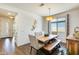 The dining room boasts a wooden table, contemporary seating, statement lighting, and ample natural light at 14393 W Wethersfield Rd, Surprise, AZ 85379