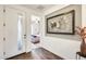 Welcoming entryway with wood-look tile flooring and modern artwork, leading to bedroom at 14393 W Wethersfield Rd, Surprise, AZ 85379