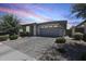 Charming home with a well-maintained front yard, featuring mature trees and a paved driveway at 14393 W Wethersfield Rd, Surprise, AZ 85379