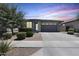Charming single-story home featuring a paved driveway, landscaped front yard, and attached two-car garage at 14393 W Wethersfield Rd, Surprise, AZ 85379