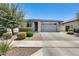 Well-maintained single-story home with landscaped front yard, a stone facade, and a two-car garage at 14393 W Wethersfield Rd, Surprise, AZ 85379