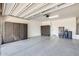 Well-lit garage with epoxy flooring, custom storage cabinets, and a water heater at 14393 W Wethersfield Rd, Surprise, AZ 85379