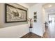 Hallway features an entry table with floral arrangement, modern art piece and beautiful tile flooring at 14393 W Wethersfield Rd, Surprise, AZ 85379