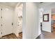 Hallway view with a glimpse of laundry area and kitchen, features wood-look tile floors at 14393 W Wethersfield Rd, Surprise, AZ 85379
