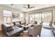 Living room with large sectional and a view of the backyard pool through sliding glass doors at 14393 W Wethersfield Rd, Surprise, AZ 85379
