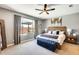 Cozy bedroom featuring neutral tones, a wood headboard, and natural light from the window at 14393 W Wethersfield Rd, Surprise, AZ 85379