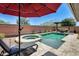 Backyard oasis features a sparkling pool, spa, brick wall, lounge chairs, and a cozy outdoor seating area at 14393 W Wethersfield Rd, Surprise, AZ 85379