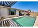 A sparkling pool and spa are enhanced by a pergola, lush greenery, and a covered patio seating area at 14393 W Wethersfield Rd, Surprise, AZ 85379