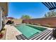 Backyard featuring a sparkling pool, spa, lounge chairs, brick wall, and desert landscaping under a clear blue sky at 14393 W Wethersfield Rd, Surprise, AZ 85379
