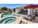 Inviting pool and spa surrounded by travertine decking, lounge chairs, and lush landscaping at 14393 W Wethersfield Rd, Surprise, AZ 85379