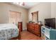 Bedroom with wood floors, a ceiling fan, and a dresser with mirror at 14436 N 162Nd Ln, Surprise, AZ 85379