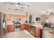 Open kitchen with stainless steel appliances, light wood cabinets, and tiled floor at 14436 N 162Nd Ln, Surprise, AZ 85379