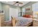 Cozy bedroom featuring a light wood bed frame, ceiling fan, and two windows with plantation shutters at 1535 W Winter Dr, Phoenix, AZ 85021