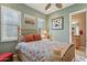 Comfortable bedroom with ceiling fan and windows boasting white plantation shutters, next to the bathroom at 1535 W Winter Dr, Phoenix, AZ 85021