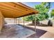 Covered patio overlooks the low maintenance backyard with desert landscaping and mature trees at 2822 N 90Th Ave, Phoenix, AZ 85037