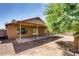 The backyard features a covered patio, desert landscaping, mature trees, and privacy wall at 2822 N 90Th Ave, Phoenix, AZ 85037