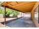 Covered patio overlooks the low maintenance backyard with desert landscaping and mature trees at 2822 N 90Th Ave, Phoenix, AZ 85037