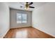 A cozy bedroom featuring a ceiling fan, window with blinds, and wood-look flooring at 2822 N 90Th Ave, Phoenix, AZ 85037