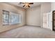 Bedroom with neutral carpet, a ceiling fan, and a bright window at 2822 N 90Th Ave, Phoenix, AZ 85037