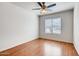 A cozy bedroom featuring a ceiling fan, window with blinds, and wood-look flooring at 2822 N 90Th Ave, Phoenix, AZ 85037