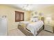 Cozy bedroom showcasing a plush carpet, decorative light fixture and window with wood shutters at 31453 N Blackfoot Dr, San Tan Valley, AZ 85143