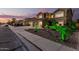 Attractive two-story home boasts a well-manicured front yard with vibrant, illuminated landscaping at 31453 N Blackfoot Dr, San Tan Valley, AZ 85143