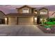 Stunning two-story home featuring a three-car garage and tile roof at dusk at 31453 N Blackfoot Dr, San Tan Valley, AZ 85143