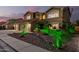 Attractive home showcasing desert landscaping with distinctive green lighting and a spacious three-car garage at 31453 N Blackfoot Dr, San Tan Valley, AZ 85143