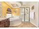 Main bathroom showcasing a glass enclosed shower, soaking tub, tile floors and backsplash at 31453 N Blackfoot Dr, San Tan Valley, AZ 85143