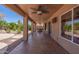 Relaxing covered patio area features a ceiling fan and views of the lush desert landscaping at 31453 N Blackfoot Dr, San Tan Valley, AZ 85143