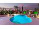 Inviting backyard pool with rock waterfall and lush desert landscaping highlighted by colorful sunset at 31453 N Blackfoot Dr, San Tan Valley, AZ 85143