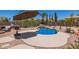 Sparkling pool features a waterfall, desert landscaping, and an umbrella for shade at 31453 N Blackfoot Dr, San Tan Valley, AZ 85143