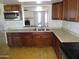 Kitchen features granite counters and dark cabinetry, with view to living area at 3171 W Orchid Ln, Phoenix, AZ 85051