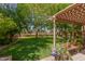 Shaded patio area surrounded by a lush green yard and mature trees at 3274 E Denim Trl, San Tan Valley, AZ 85143