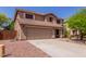 Two-story home with a large driveway and desert landscaping, providing ample parking and curb appeal at 3274 E Denim Trl, San Tan Valley, AZ 85143