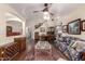 Open-concept living room featuring hardwood floors, a ceiling fan, and an adjacent dining area for seamless entertaining at 3274 E Denim Trl, San Tan Valley, AZ 85143