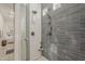 The frameless shower features gray horizontal tiling and white tiles with a glass block window at 3406 E Pyrenees Pass, Phoenix, AZ 85018