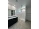 Modern bathroom showcasing a double vanity sink, a walk-in shower, and tiled floors at 38070 W Frascati Ave, Maricopa, AZ 85138