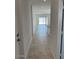 Hallway with tiled floors, white walls, and an open view to the living room and backyard at 38070 W Frascati Ave, Maricopa, AZ 85138