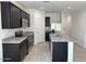Stylish kitchen features black cabinetry, granite countertops, stainless steel appliances and a kitchen island at 38070 W Frascati Ave, Maricopa, AZ 85138