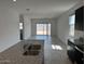 Bright living area with sleek granite countertops, black appliances, and an open-concept layout leading to a backyard at 38070 W Frascati Ave, Maricopa, AZ 85138