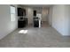 Open-concept living area with modern black appliances, granite countertops, and tile flooring, ideal for entertaining at 38070 W Frascati Ave, Maricopa, AZ 85138