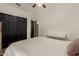 Bedroom featuring a ceiling fan, black closet doors, and a modern white desk at 3946 N 112Th Ave, Avondale, AZ 85392