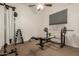 Home gym including weight-lifting bench, racks, machine and a ceiling fan at 3946 N 112Th Ave, Avondale, AZ 85392