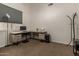 Bright home office with an L-shaped desk, comfortable chair, and modern décor at 3946 N 112Th Ave, Avondale, AZ 85392