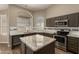 Well-equipped kitchen features granite counters, tiled backsplash, stainless steel appliances, and a center island at 3946 N 112Th Ave, Avondale, AZ 85392