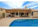 Inviting pool area with a covered patio, outdoor seating, and meticulously landscaped surroundings at 3946 N 112Th Ave, Avondale, AZ 85392