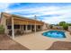 Inviting pool area with a covered patio, outdoor seating, and meticulously landscaped surroundings at 3946 N 112Th Ave, Avondale, AZ 85392