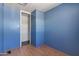 A bedroom featuring blue walls, laminate flooring, and a closet at 4065 E University Dr # 228, Mesa, AZ 85205